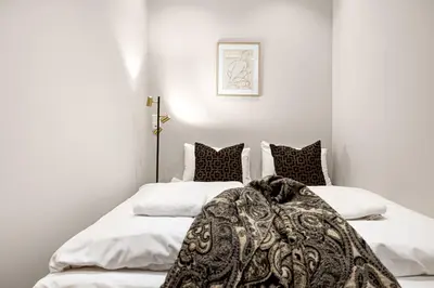 two beds in a room with white walls at Heimby Homes - Seaside Balcony Stay in Bergen