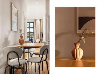 a dining room with a table and chairs and a vase at Heimby Homes - Seaside Balcony Stay in Bergen