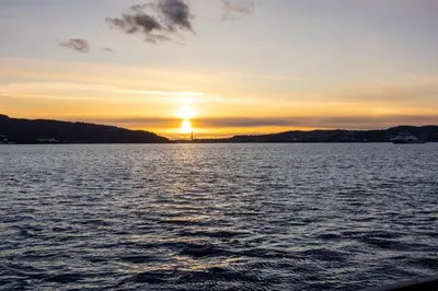 a sunset over a large body of water at Heimby Homes - Seaside Balcony Stay in Bergen