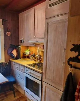 a kitchen with wooden cabinets and a stove top oven at Bloksberg - cabin with amazing view and ski inn-out in Geilo