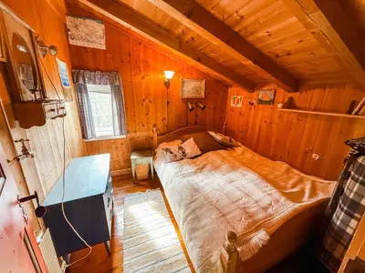 a bedroom with a bed in a wooden cabin at Bloksberg - cabin with amazing view and ski inn-out in Geilo