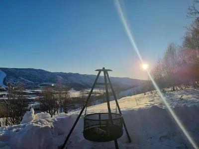 a swing in the snow with the sun in the background at Bloksberg - cabin with amazing view and ski inn-out in Geilo