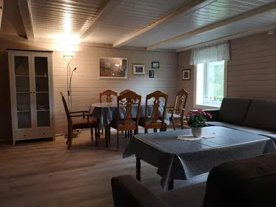 a living room with a table and chairs and a couch at Hansali Holiday Home in Fjarland