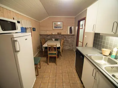 a kitchen with a table and a white refrigerator at Hansali Holiday Home in Fjarland
