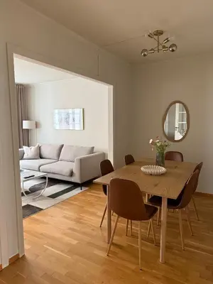a living room with a table and a couch at Romslig leilighet midt i Bergen sentrum - komfort med kvalitetsenger og dyner in Bergen