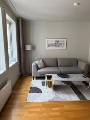 a living room with a couch and a coffee table at Romslig leilighet midt i Bergen sentrum - komfort med kvalitetsenger og dyner in Bergen