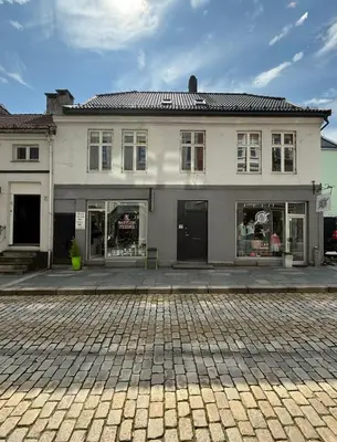 a large white building with windows on a street at Romslig leilighet midt i Bergen sentrum - komfort med kvalitetsenger og dyner in Bergen