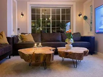 a living room with a couch and two wooden tables at Renovated 1918 House By The Sea In Sandeid in Sandeid