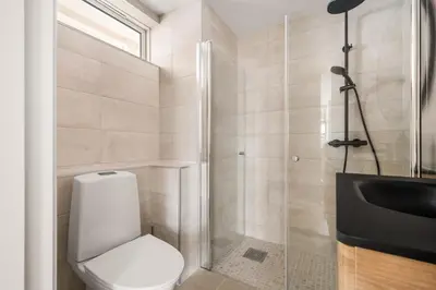 a bathroom with a toilet and a glass shower at City Apartment I Short Walk to Sights in Bergen