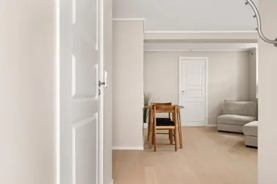 an open door to a living room with a chair and a table at City Apartment I Short Walk to Sights in Bergen