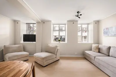 a living room with a couch and chairs and a tv at City Apartment I Short Walk to Sights in Bergen