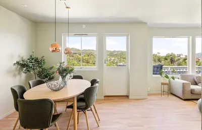 a dining room with a table and chairs and a couch at Sentrumsnær bolig in Lii