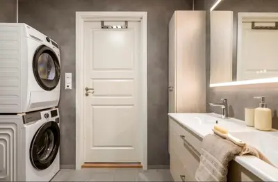 a bathroom with a washing machine and a sink at Sentrumsnær bolig in Lii