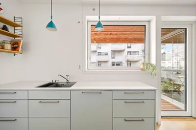 a kitchen with white cabinets and a window at Modern & Spacious City Apartment in Bergen