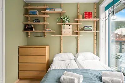 a bedroom with two beds and shelves and a window at Modern & Spacious City Apartment in Bergen