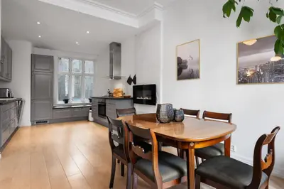 a kitchen and dining room with a wooden table and chairs at Unique and Spacious Home in Bergens Most Charming Area in Bergen
