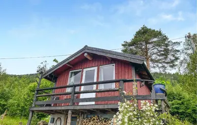 a red house with a balcony on top of it at 1 Bedroom Amazing Home In Tingvoll in Tingvoll