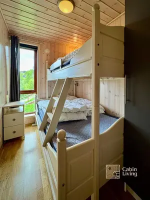 a bedroom with two bunk beds in a cabin at Ski-In Out apt Hafjell - Sauna and Stunning Views in Hafjell