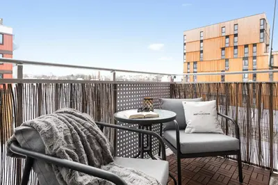 a balcony with a chair and a table on a balcony at Cozy apartment Trondheim, free parking in the basement in Trondheim