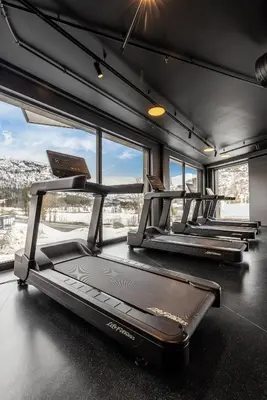 a row of treadmills in a gym with windows at Fritidsbolig i Hemsedal in Kyrkjebøen