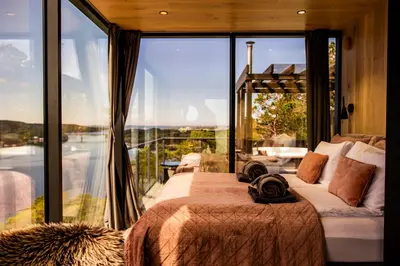 a bedroom with a bed and a large glass window at Speilhus med badestamp - en unik naturopplevelse in Solem
