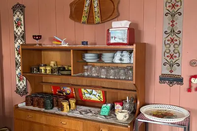 a kitchen with a shelf with plates and glasses at Voi Voi Bed & Breakfast in Røros