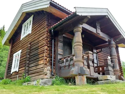 a log cabin with a large porch and windows at Beautiful place among forests and fields in a good old style in Eggedal