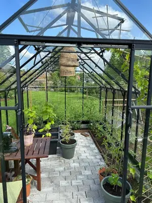 a greenhouse with a table and potted plants at Modern house - perfect for holidays in Bergen in Bergen