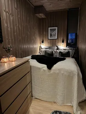 a bedroom with a bed with a white blanket on it at Moderne leilighet ski inn og ski ut med magisk natur in Lii