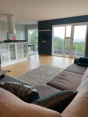 a living room with a couch and some windows at Panorama leilighet in Lii