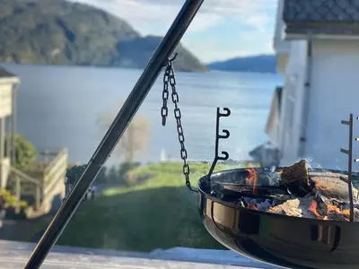 a fire pit on a balcony with a view of the water at The View in Sauda