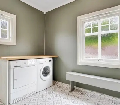 a laundry room with a washing machine and a window at The View in Sauda