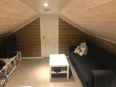 a living room with a couch and a table at Familiehytte på Kvamskogen in Kvam