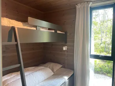 a bunk bed in a log cabin with a window at The Lookout at Beitostølen in Beitostøl