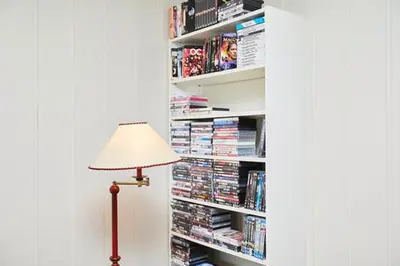 a lamp in front of a book shelf with books at Fisking i Valdres in Tisleidalen