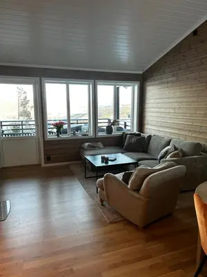 a living room with a couch and a table at Flott leilighet på Voss i Tråstølsvegen med 3 soverom 6 sengeplasser in Skulestadmo