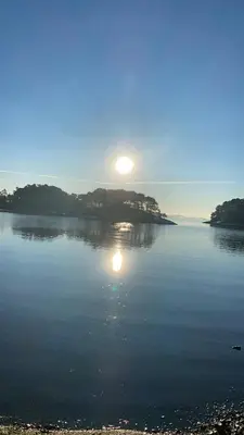 a large body of water with the sun in the sky at Colorful family apartment near the sea - boat for rent