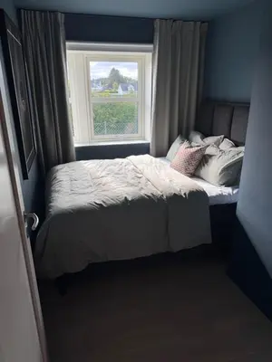 a small bed in a room with a window at Colorful family apartment near the sea - boat for rent