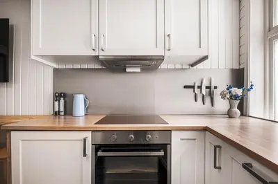 a kitchen with white cabinets and a stove top oven at Bergen pearl in historic street & easy check-in in Bergen