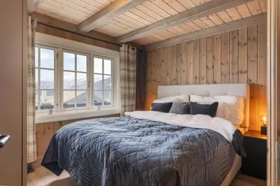 a bedroom with a large bed in a room with wooden walls at The national park is calling! in Garden