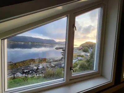 a window with a view of a lake at Hytte ved sjøen in Røyra