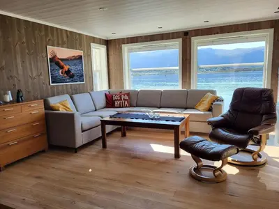a living room with a couch and a table at Hytte ved sjøen in Røyra