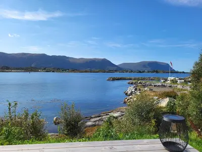 a view of a lake with mountains in the background at Hytte ved sjøen in Røyra
