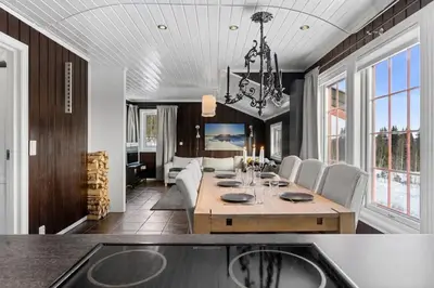 a dining room and living room with a table and chairs at Trysilfjell 720 by Vacation Trysil in Trysil