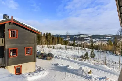 a house in the snow with cars parked next to it at Trysilfjell 720 by Vacation Trysil in Trysil