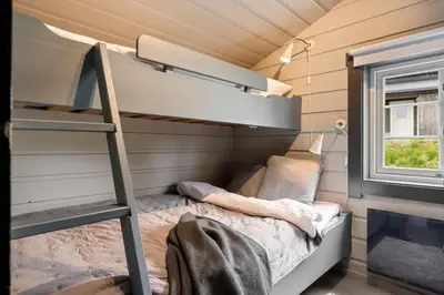 a small bedroom with a bunk bed and a ladder at Cozy Skilodge ski in & out in Trysil in Trysil