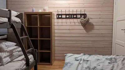 a bedroom with a wooden wall with a shelf at Ski-In, Ski-Out apartment at Filefjell in Tyinkrysset