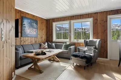 a living room with a couch and a table and two chairs at Trysilfjell 786 by Vacation Trysil in Trysil