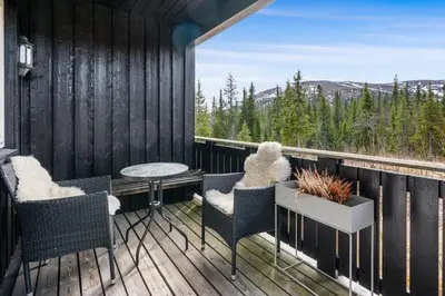 a balcony with chairs and a table and a view at Trysilfjell 782 by Vacation Trysil in Trysil