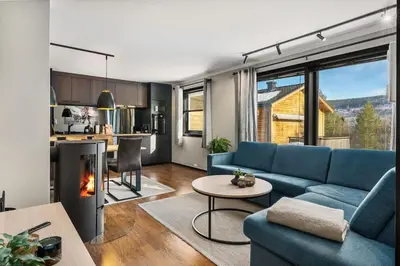a living room with a blue couch and a fireplace at Trysilfjell 33 by Vacation Trysil in Trysil